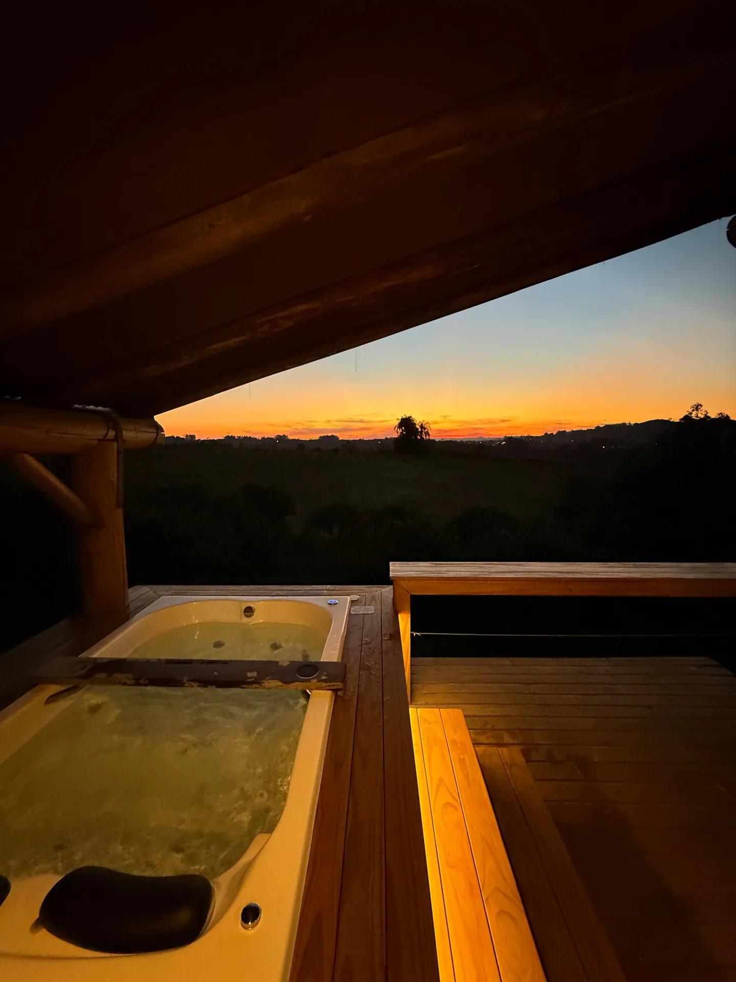 Jacuzzi dupla na sacada da suíte, com o pôr do sol sobre o vale