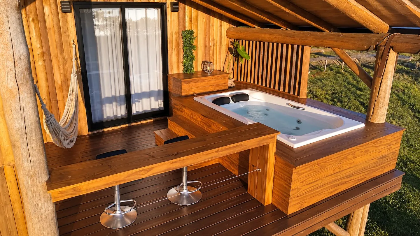 Sacada da suíte com a jacuzzi, bancada e banquetas
