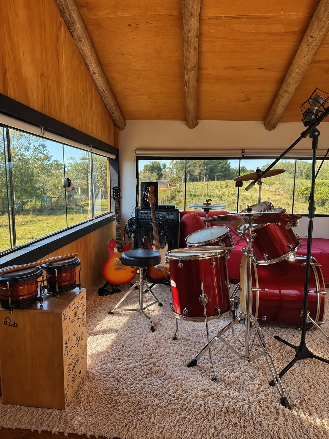 Studio musical com bateria e janelas para o verde
